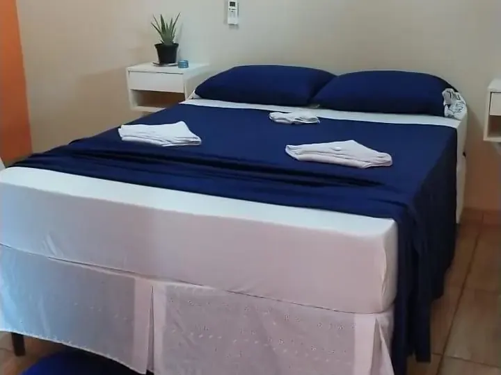 Quarto de casal com colcha azul na Pousada Estrela de Davi