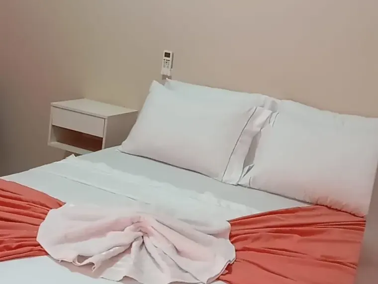 Quarto de casal com enxoval claro e criado-mudo