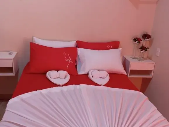 Quarto de casal com enxoval vermelho e decoração